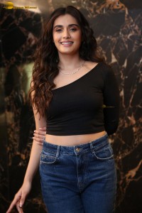 actress divyansha kaushik in a black top and denim jeans