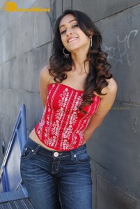 Actress Ileana D’Cruz in a red top and blue jeans posing for a photoshoot