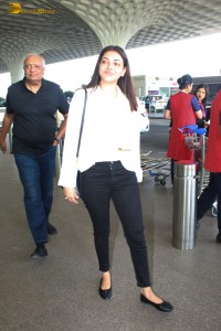 actress Kajal Aggarwal in a white top and black jeans