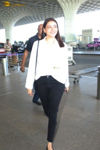 actress Kajal Aggarwal in a white top and black jeans