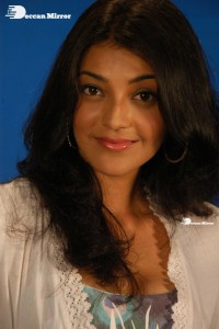 Actress Kajal Aggarwal in a green dress and a white coat