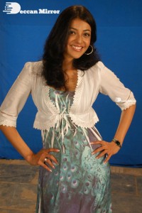 Actress Kajal Aggarwal in a green dress and a white coat