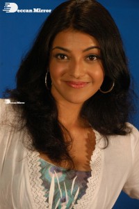 Actress Kajal Aggarwal in a green dress and a white coat