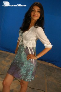 Actress Kajal Aggarwal in a green dress and a white coat