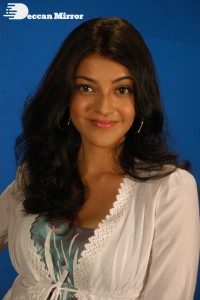 Actress Kajal Aggarwal in a green dress and a white coat