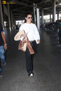 actress kajol chic look in a white top at airport