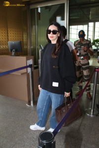 actress Karisma Kapoor in a black top and denim jeans at airport