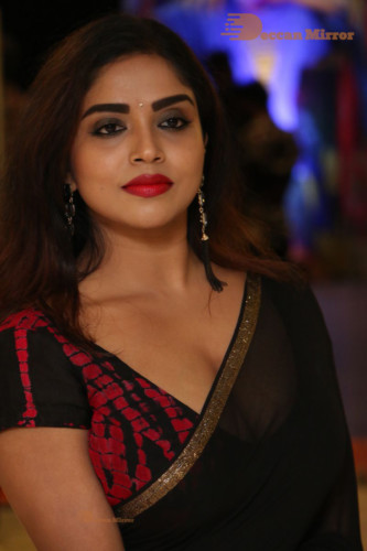 Telugu Actress Karunya Chowdary dressed in a black saree posing for photos