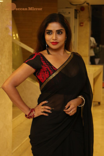 Telugu Actress Karunya Chowdary dressed in a black saree posing for photos