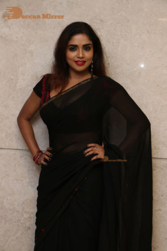 Telugu Actress Karunya Chowdary dressed in a black saree posing for photos