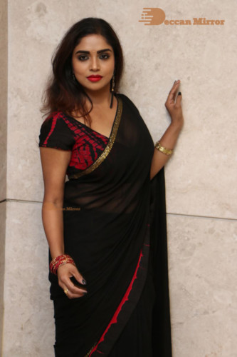 Telugu Actress Karunya Chowdary dressed in a black saree posing for photos