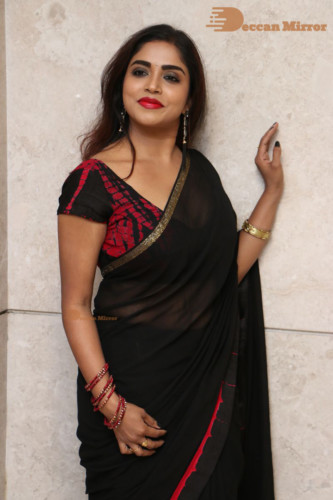 Telugu Actress Karunya Chowdary dressed in a black saree posing for photos