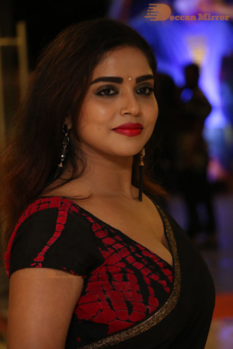 Telugu Actress Karunya Chowdary dressed in a black saree posing for photos
