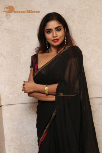 Telugu Actress Karunya Chowdary dressed in a black saree posing for photos