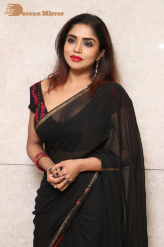 Telugu Actress Karunya Chowdary dressed in a black saree posing for photos