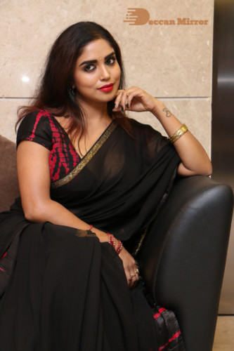 Telugu Actress Karunya Chowdary dressed in a black saree posing for photos