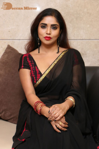 Telugu Actress Karunya Chowdary dressed in a black saree posing for photos