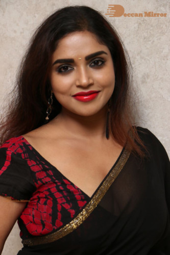Telugu Actress Karunya Chowdary dressed in a black saree posing for photos