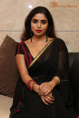 Telugu Actress Karunya Chowdary dressed in a black saree posing for photos