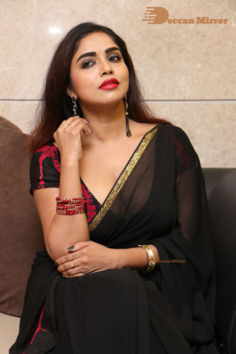 Telugu Actress Karunya Chowdary dressed in a black saree posing for photos