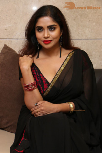 Telugu Actress Karunya Chowdary dressed in a black saree posing for photos
