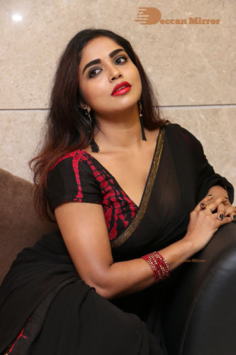 Telugu Actress Karunya Chowdary dressed in a black saree posing for photos