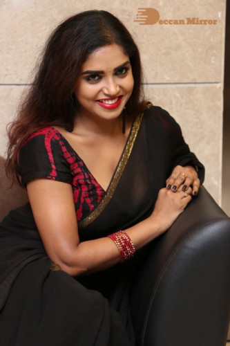 Telugu Actress Karunya Chowdary dressed in a black saree posing for photos