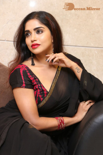 Telugu Actress Karunya Chowdary dressed in a black saree posing for photos