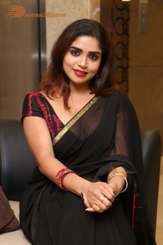 Telugu Actress Karunya Chowdary dressed in a black saree posing for photos