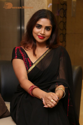 Telugu Actress Karunya Chowdary dressed in a black saree posing for photos