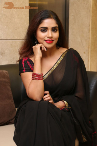 Telugu Actress Karunya Chowdary dressed in a black saree posing for photos