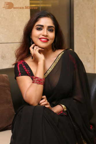Telugu Actress Karunya Chowdary dressed in a black saree posing for photos