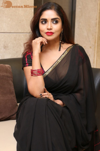 Telugu Actress Karunya Chowdary dressed in a black saree posing for photos