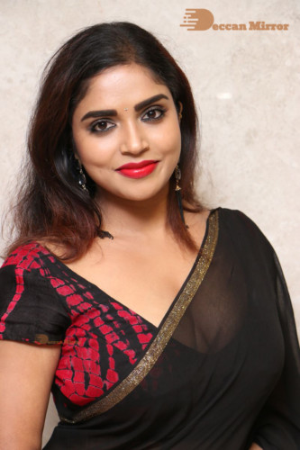 Telugu Actress Karunya Chowdary dressed in a black saree posing for photos