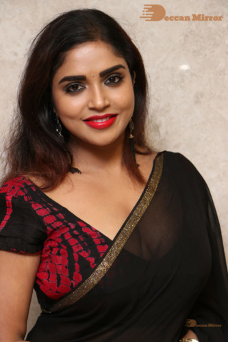 Telugu Actress Karunya Chowdary dressed in a black saree posing for photos