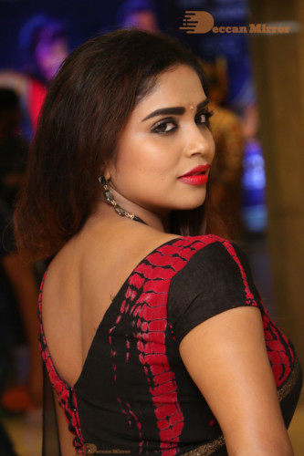 Telugu Actress Karunya Chowdary dressed in a black saree posing for photos