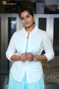 Indian Actress Kavya Kalyanram in a white shirt and blue skirt