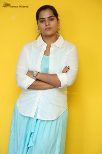 Indian Actress Kavya Kalyanram in a white shirt and blue skirt