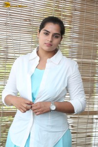 Indian Actress Kavya Kalyanram in a white shirt and blue skirt