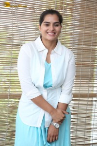 Indian Actress Kavya Kalyanram in a white shirt and blue skirt