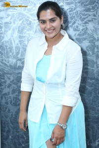 Indian Actress Kavya Kalyanram in a white shirt and blue skirt
