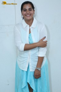 Indian Actress Kavya Kalyanram in a white shirt and blue skirt