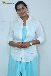 Indian Actress Kavya Kalyanram in a white shirt and blue skirt
