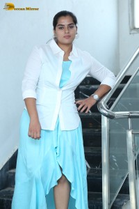 Indian Actress Kavya Kalyanram in a white shirt and blue skirt