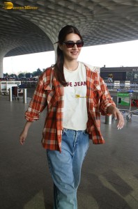 actress Kriti Sanon in a colorful shirt and denim jeans