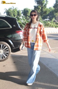 actress Kriti Sanon in a colorful shirt and denim jeans