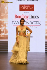 actress malaika arora stunning in a yellow dress doing a ramp walk