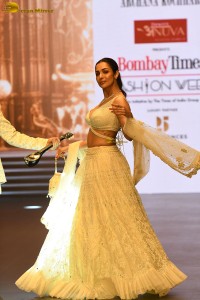 actress malaika arora stunning in a yellow dress doing a ramp walk