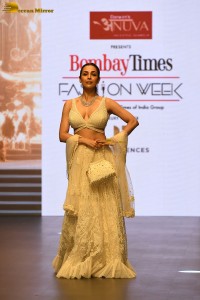 actress malaika arora stunning in a yellow dress doing a ramp walk