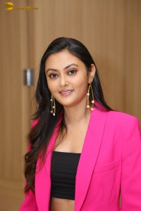 Tollywood actress megha chowdhury in a black top and pink overcoat